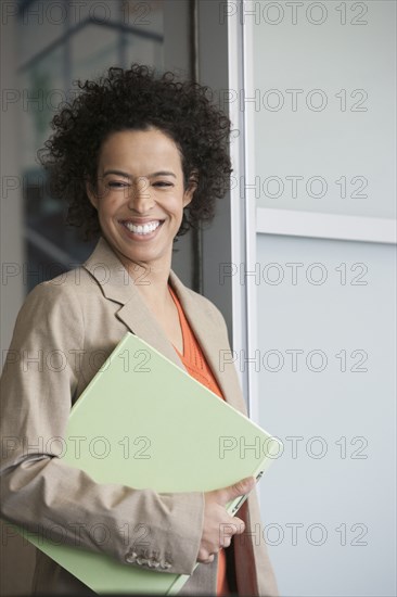 Hispanic businesswoman smiling in doorway