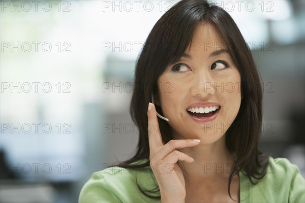 Asian businesswoman talking on headset