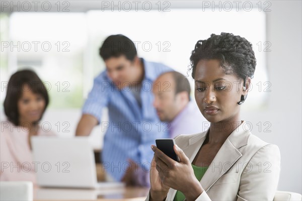 Businesswoman using cell phone in office