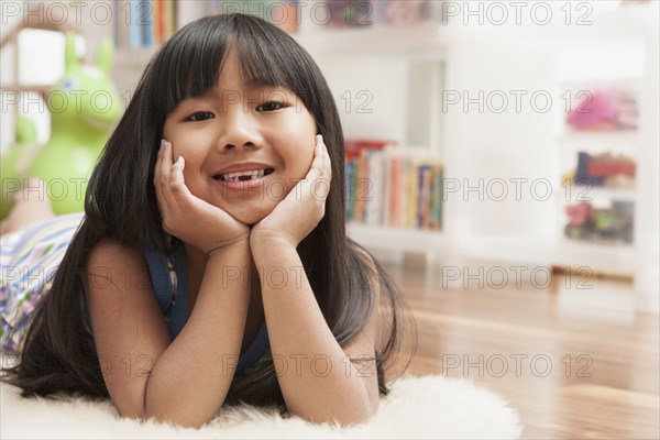 Chinese girl laying with chin in hands