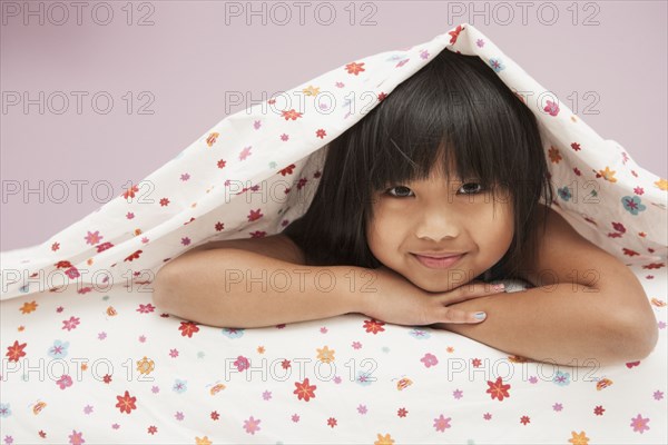 Chinese girl laying under covers