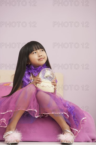 Chinese girl playing with snow globe
