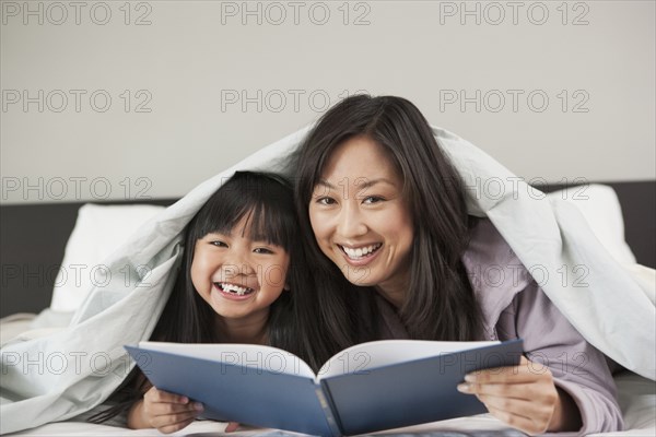 Mother and daughter reading in bed