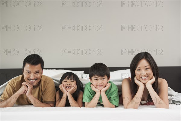 Family laying together on bed