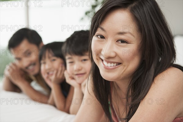 Family laying together on bed