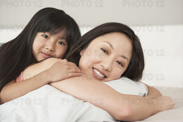 Mother and daughter laying on bed