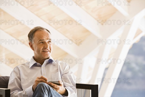 Man using cell phone in armchair