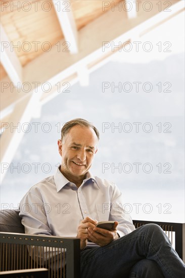Man using cell phone in armchair