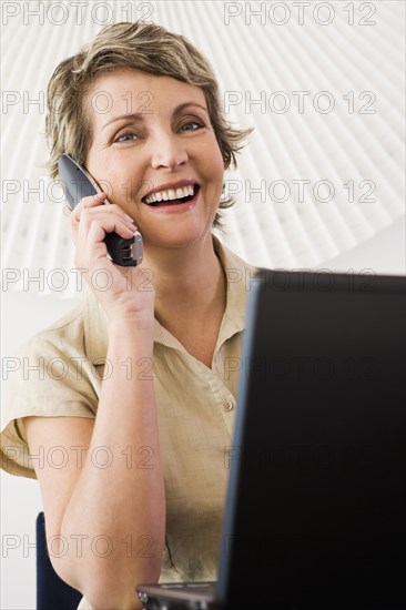 Businesswoman talking on phone in office