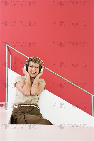 Woman listening to headphones on stairs