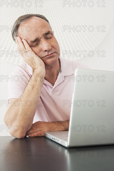 Businessman napping at desk in office