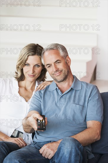 Couple watching television in living room