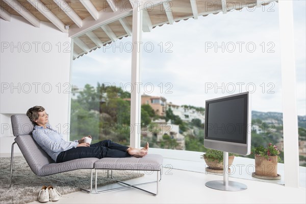 Woman watching television in living room