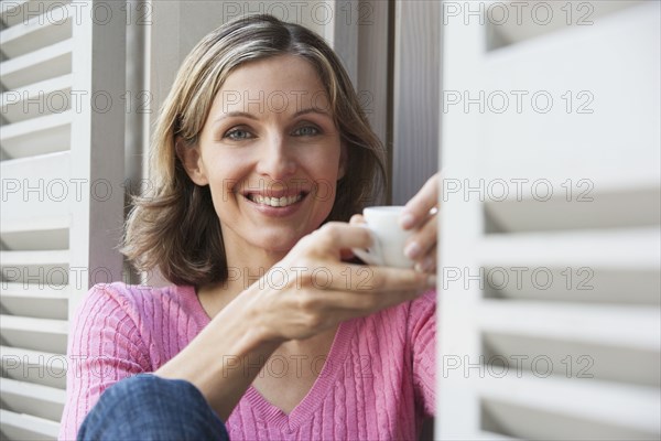 Woman having cup of coffee outdoors