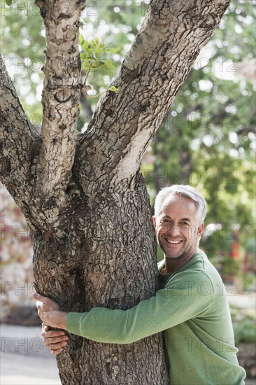 Man hugging tree outdoors