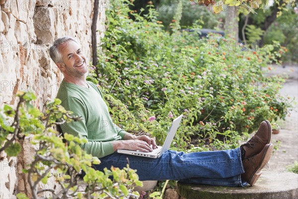 Man using laptop in backyard