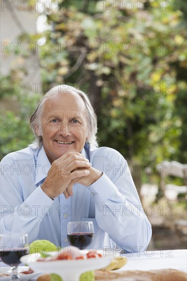 Man eating at table outdoors