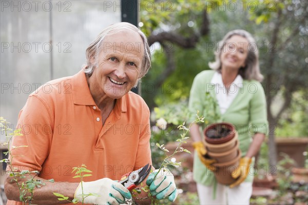 Couple potting plants in greenhouse