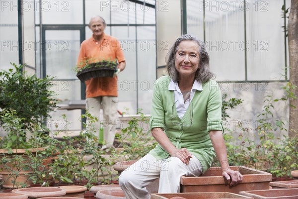 Couple potting plants in greenhouse