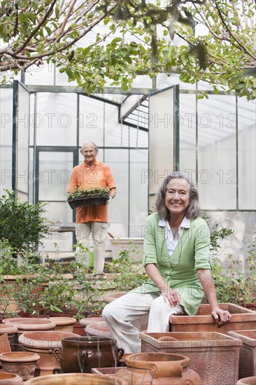 Couple potting plants in greenhouse