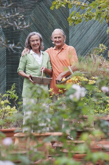 Couple tending plants in greenhouse