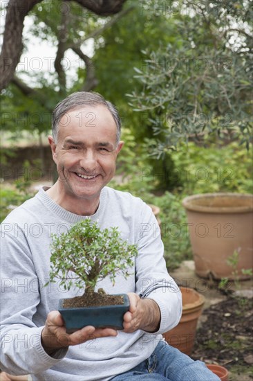 Man holding potted bonsai tree