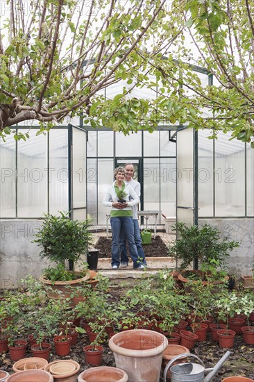 Couple smiling in greenhouse