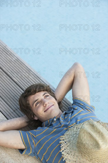 Man relaxing by swimming pool