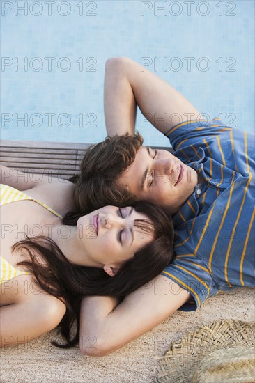 Couple relaxing by swimming pool