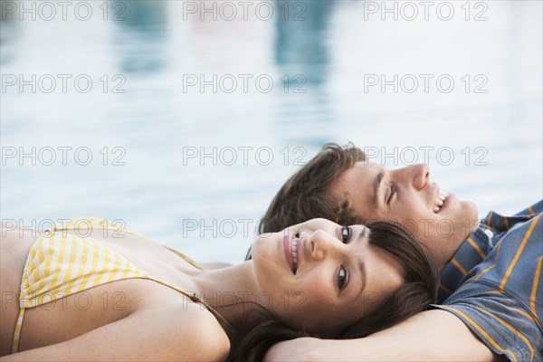 Couple relaxing by swimming pool