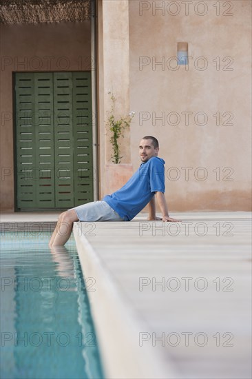 Man relaxing by swimming pool