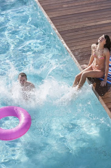 Couple splashing in swimming pool