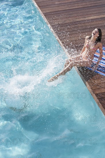 Woman splashing in swimming pool