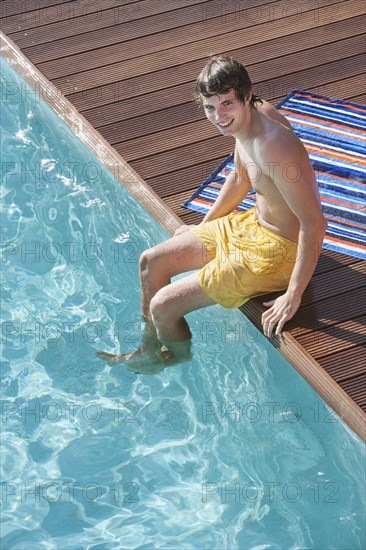 Man sitting by swimming pool