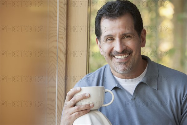 Hispanic man having cup of coffee