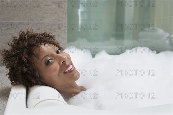 African American woman relaxing in bubble bath