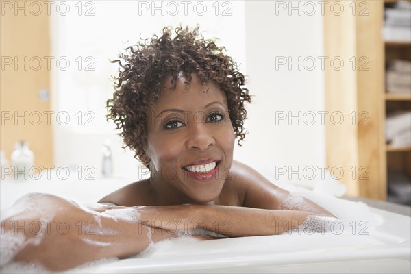 African American woman relaxing in bubble bath