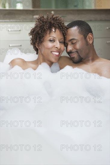 African American couple relaxing in bath