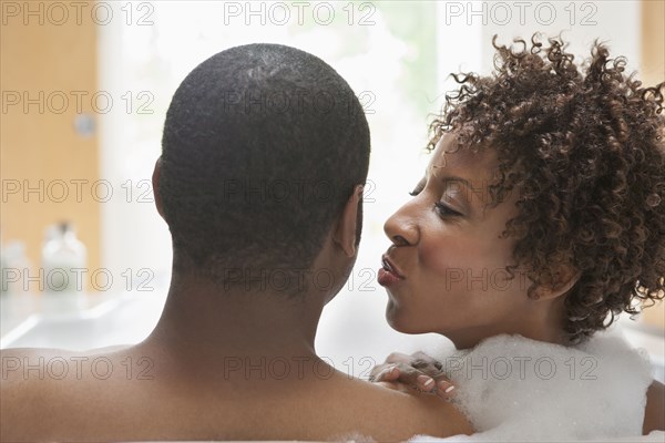 African American couple relaxing in bath