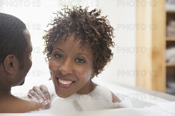 African American couple relaxing in bath