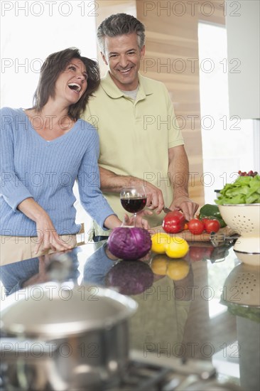 Hispanic couple cooking in kitchen