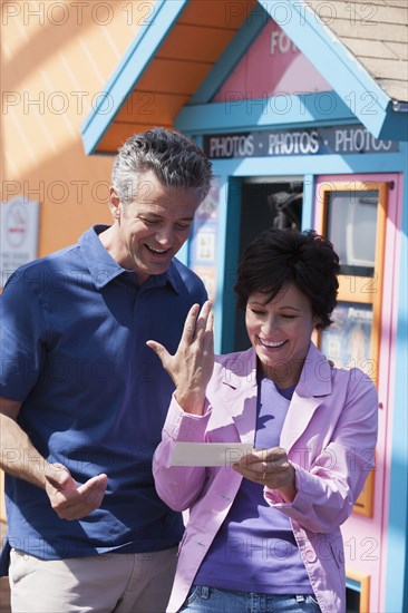 Caucasian couple getting instant photos