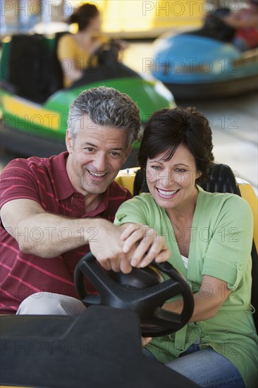 Caucasian couple driving bumper car