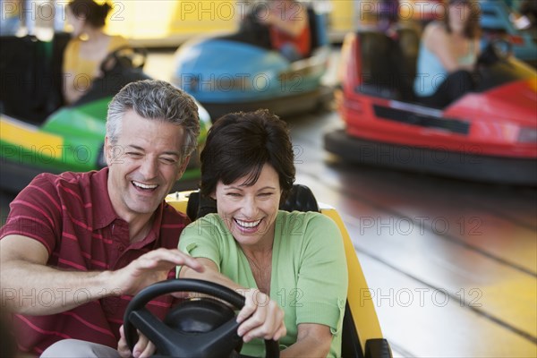 Caucasian couple driving bumper car