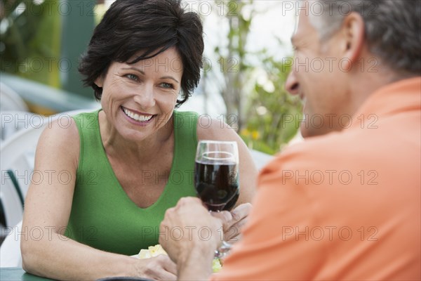 Caucasian couple toasting each other with wine