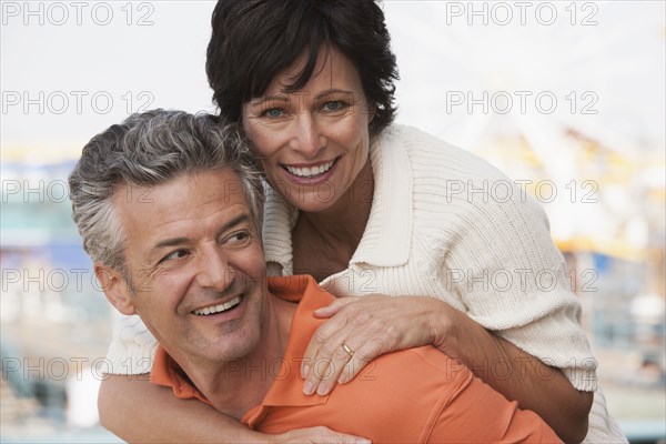 Caucasian man carrying girlfriend piggyback