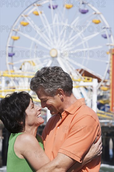 Caucasian couple hugging at theme park