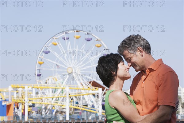 Caucasian couple hugging at theme park