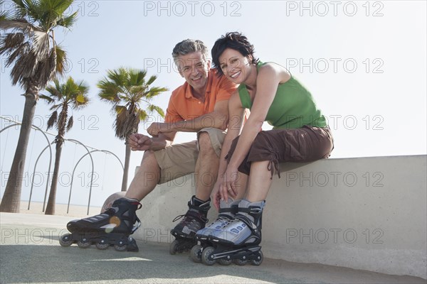 Caucasian couple rollerblading by beach