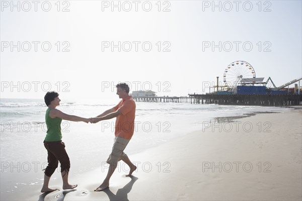 Caucasian couple walking on beach